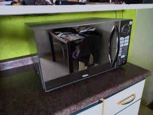 un four micro-ondes installé sur un comptoir dans une cuisine dans l'établissement Apartamento bem localizado, à Diamantina