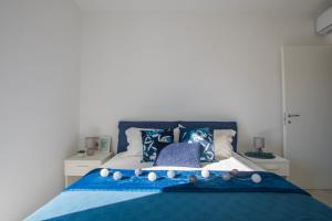 a bedroom with a blue bed with pillows at Pietra di Luna in Valledoria