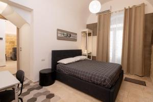 a bedroom with a black bed in a room at Santa Lucia Affittacamere in Gioia del Colle