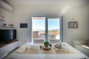 a living room with a table and a large window at Pietra di Luna in Valledoria