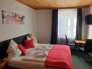 a bedroom with a bed with a red blanket at Weisses Rössel-Cavallo Bianco in Werfen