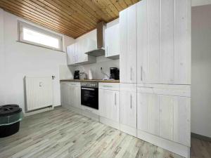 une cuisine blanche avec des armoires blanches et une fenêtre dans l'établissement SAD104 - Moderne Monteurwohnung/Übergangswohnung, à Schwandorf in Bayern 5 autres photos