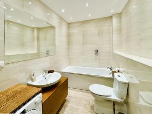 a bathroom with a toilet and a sink and a tub at Romantica SPA Kraków in Kraków