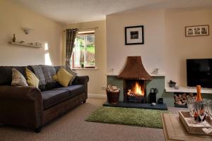 a living room with a couch and a fireplace at Finest Retreats - Tan-Y-Dderwen in Aberhafesp