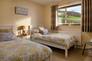 1 dormitorio con 2 camas y ventana en Finest Retreats - Tan-Y-Dderwen, en Aberhafesp