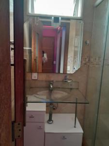 リオデジャネイロにあるSuíte confortavelのバスルーム(洗面台、鏡付)