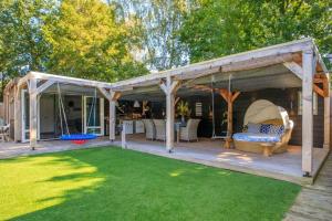 a pergola with a couch on a patio at Bohemian Island incl boat supboards and pool 5 minutes by boat from parking to the bohemien in Loosdrecht