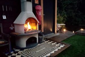 un horno de pizza al aire libre sentado en la parte superior de un patio en Bohemian Island incl boat supboards and pool 5 minutes by boat from parking to the bohemien, en Loosdrecht