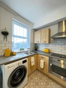a kitchen with a washing machine and a sink at Cosy home in Barnsley centre in Barnsley