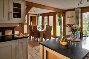 a kitchen with a table and a dining room at Finest Retreats - Ty Nant in Aberhafesp