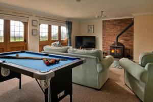 a living room with a pool table and a fireplace at Finest Retreats - Ty Nant in Aberhafesp