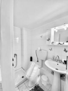 a white bathroom with a toilet and a sink at City's heart in Agios Nikolaos