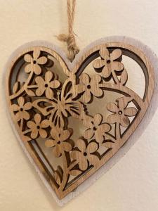 a wooden heart ornament with flowers on a wall at City's heart in Agios Nikolaos