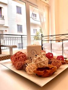 a plate of pastries on a table with a window at City's heart in Agios Nikolaos
