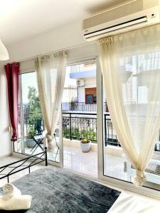 a living room with large windows and a balcony at City's heart in Agios Nikolaos