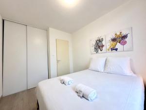 1 dormitorio con 1 cama blanca y 2 toallas en LES 3 RIVIÈRES - Vue Imprenable & Hyper Centre, en Mont-de-Marsan