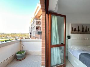 a bedroom with a window and a bed on a balcony at Nui Prestige Home in Fiumicino