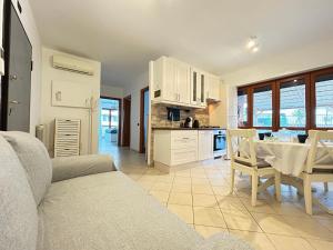 a kitchen and living room with a couch and a table at Nui Prestige Home in Fiumicino