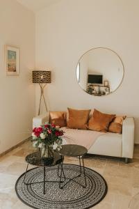 a living room with a couch and a round mirror at Pissenlit Une Prairie en Provence in Arles