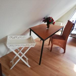 una mesa con un jarrón de flores y dos sillas en Ferienhaus im Grünen en Alt Krenzlin