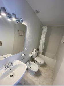 a bathroom with a sink and a toilet and a mirror at Hotel Las Camelias in Sotogrande