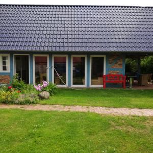 una casa con techo azul y patio en Ferienhaus im Grünen, en Alt Krenzlin