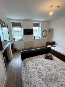 a bedroom with a bed and a couch and a television at Parade School Guest Rooms in Berwick-Upon-Tweed