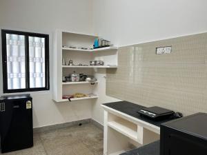 a kitchen with a desk and a window in a room at SAIBALA HOMESTAY - AC 1 BHK NEAR AlRPORT in Chennai