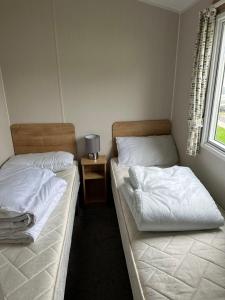 dos camas sentadas una al lado de la otra en un dormitorio en Powys 37 en Borth
