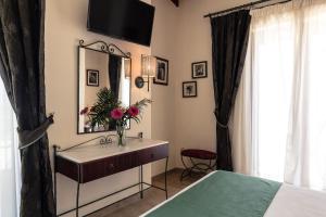 una camera con lavandino, specchio e letto di Agistri Hotel a Skala