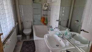 een witte badkamer met een wastafel en een toilet bij Ferienhaus LIANE 