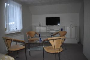 Una mesa de comedor con sillas y un televisor. en Ferienhaus LIANE, en Breitenbrunn
