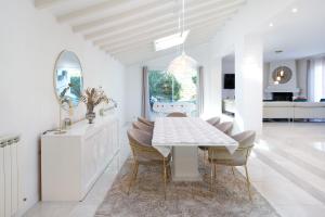 a white dining room with a table and chairs at Villa standing Biarritz in Biarritz