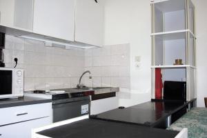 een keuken met een wastafel en een magnetron bij Appartement champêtre - Déconnexion assurée in Poitiers