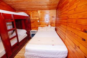 a small room with a bed in a wooden cabin at Cabin Renty Beach in Encarnación