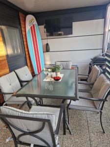 mesa y sillas en una habitación con tabla de surf en Mobile home Mia en Privlaka