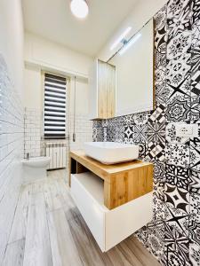 W łazience znajduje się umywalka, toaleta i lustro. w obiekcie Vacanze Romane w mieście Lido di Ostia