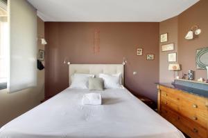 ein Schlafzimmer mit einem großen weißen Bett und einer Kommode in der Unterkunft - L'Idylle de Clamart - in Clamart