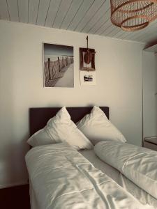 a bed with white sheets and a picture of a pier at ANINA in Meckenheim