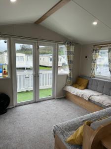a living room with a couch and windows at Powys 37 in Borth