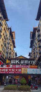 a city street with tall buildings with signs on them at Doudou Meilan Fengqing Inn in Jinghong