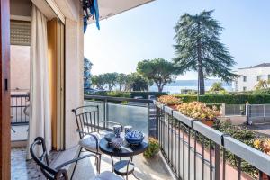 Un balcón con mesa y sillas y vista al mar. en Spiaggia d'oro Apartment Lake View, en Montecucco