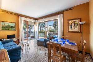 sala de estar con mesa y sofá azul en Spiaggia d'oro Apartment Lake View, en Montecucco