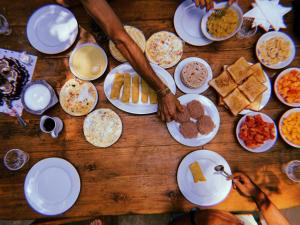 AURORA Midigama في آهانغاما: طاولة خشبية مليئة بالكثير من الأطباق من الطعام
