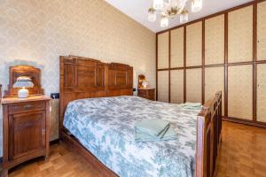 1 dormitorio con 1 cama grande y armario de madera en Spiaggia d'oro Apartment Lake View, en Montecucco
