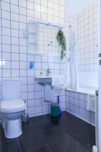 a white bathroom with a toilet and a sink at 1 minute from Royal Mile, Large 5 Bed Apartment in Edinburgh