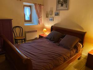 sypialnia z dużym łóżkiem z fioletową pościelą w obiekcie Gîte du petit Taïchou w mieście Luzenac