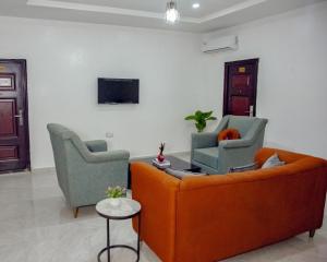 a living room with a couch and two chairs at Nexus Xpress Hotel in Abuja