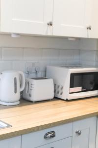 a kitchen counter with a microwave and a toaster at Cosy house in West Yorkshire in Batley