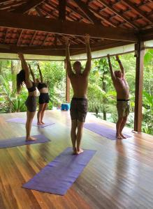 a group of people standing in a yoga class at Trindade Sea and Forest Yoga Hostel in Trindade